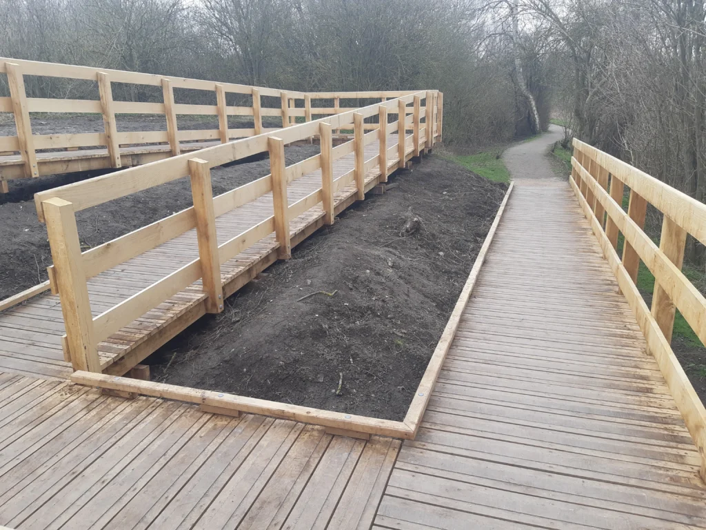 Ponton sur pilotis tout bois avec garde-corps à lisses horizontales, chasse-roues et rampes d'accès PMR